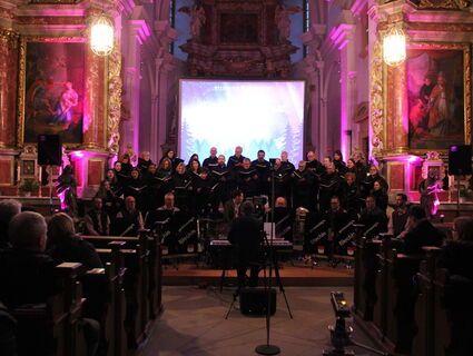Chor und Band in einer farbig beleuchteten Kirche