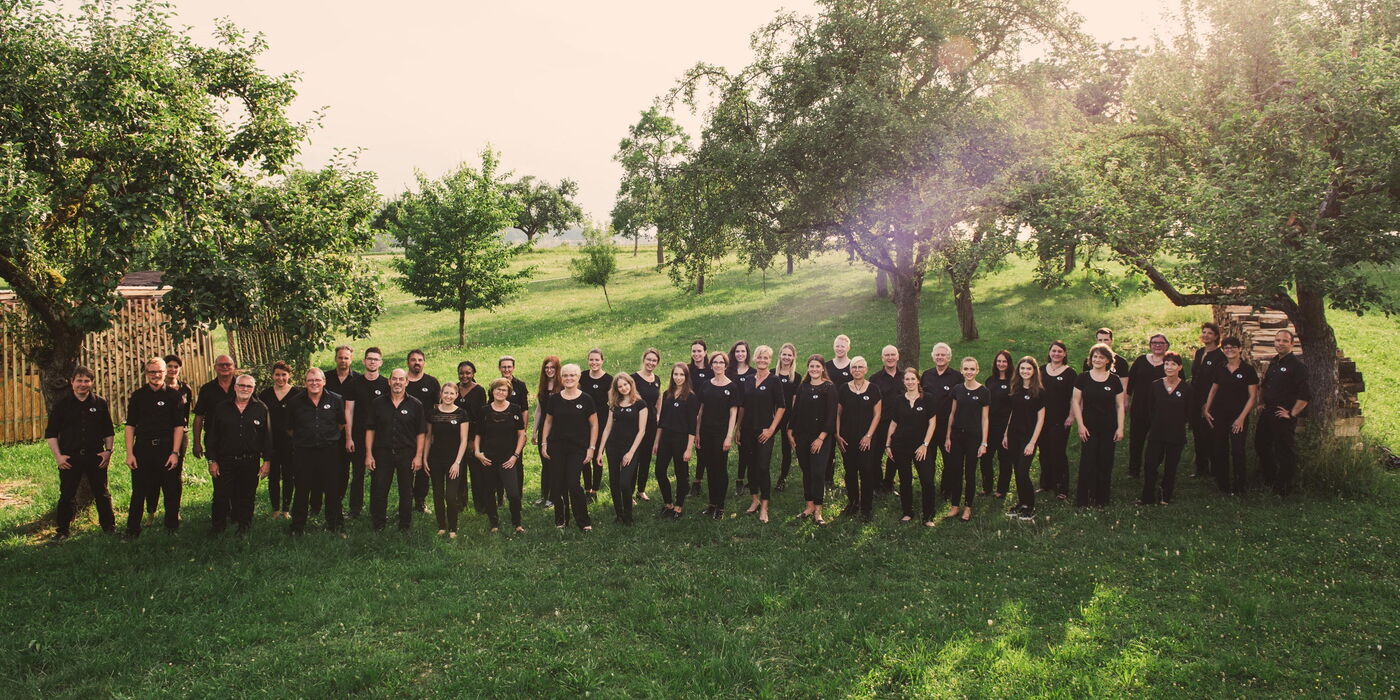 Gruppenfoto auf einer Wiese unter Obstbäumen