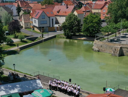 Ein Chor steht vor einer Wasserfläche